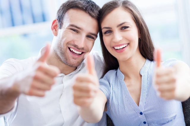 Young couple with thumbs up